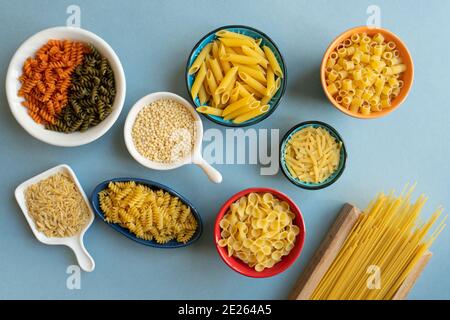 pâtes en céramique et bol en bois. penne, spaghetti, tonde farfalle, papillon, tarière, couscous, pâtes colorées, nouilles d'orge, kesme, erişte, dalitini Banque D'Images