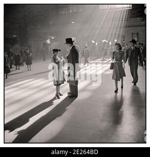 GRAND CENTRAL STATION RETRO 1940 de New York reportage "Grand Central terminal Station, New York, 1941 lumière du soleil à travers les fenêtres de la station, met en lumière les voyageurs sur le hall ayant une conversation. Style de mode et robe style de vie des années 1940 Manhattan New York États-Unis Banque D'Images