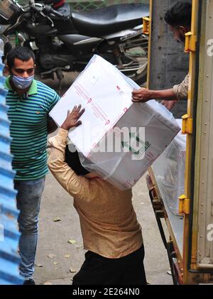 Bangalore, Inde. 12 janvier 2021. Les travailleurs transfèrent des boîtes de carton contenant des flacons de vaccin Covishield mis au point par le Serum Institute of India à leur arrivée au centre de stockage à froid du département de santé de Karnataka à Bangalore, Inde, le 12 janvier 2021. Le gouvernement fédéral indien a déclaré que la campagne de vaccination contre le COVID-19 commencera dans le pays le 16 janvier. Credit: STR/Xinhua/Alay Live News Banque D'Images