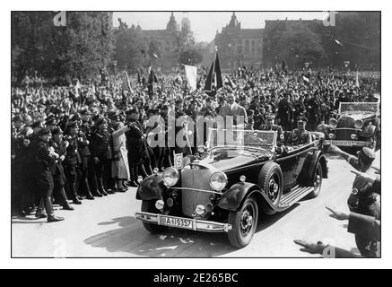 Vintage Adolf Hitler nazi Führer le leader allemand Parade avec le convoi Dans une monoplace Mercedes à ciel ouvert avec des foules éparasites agitant la swastika Drapeaux et saluant Heil Hitler à lui et à son cortège Défilé des années 1940 en Allemagne Banque D'Images