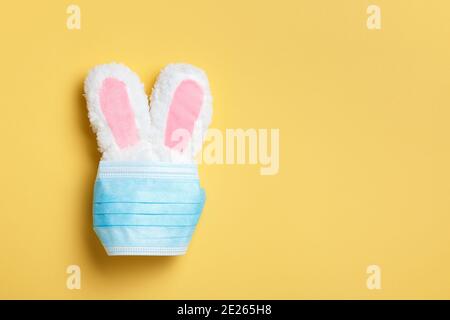 Concept de pâques de quarantaine. Lapin dans un masque médical de protection sur fond jaune. Banque D'Images