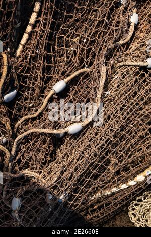 Une pile de filets de pêche sèche au soleil sur le quai. Les nœuds et les mailles du filet sont clairement visibles Banque D'Images