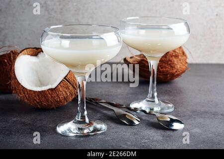 Pina Colada cocktail dans un verre et des moitiés de noix de coco. Banque D'Images