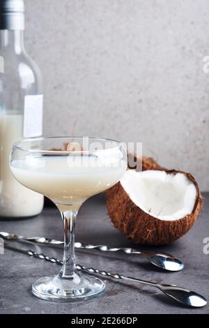 Liqueur Pina Colada dans un verre et des moitiés de noix de coco. Banque D'Images