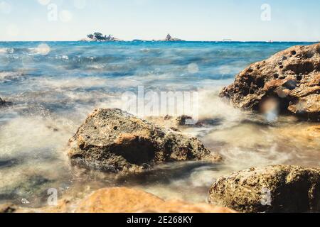 Côte rocheuse de la mer - la vague se brise sur le rocher - exposition longue Banque D'Images