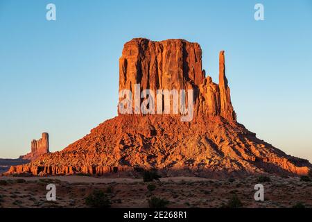 Coucher de soleil sur l'emblématique formation rocheuse de West Mitten dans le parc tribal de Monument Valley Navajo, ligne d'État de l'Arizona et de l'Utah, États-Unis Banque D'Images