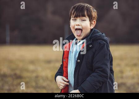 Portrait d'un mignon petit garçon qui colle de sa langue Banque D'Images