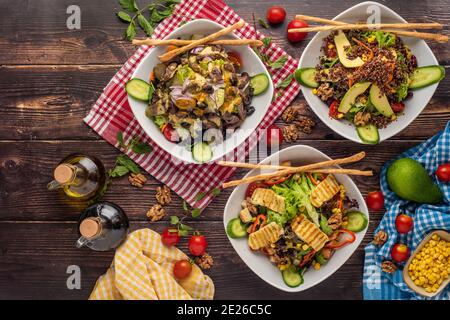 3 types de salade avec quinoa, halloumi et steak sur table en bois Banque D'Images