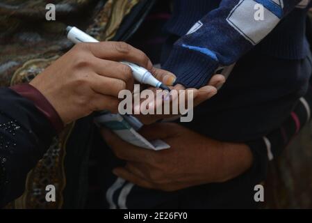 Lahore, Pakistan. 12 janvier 2021. Un travailleur de la santé pakistanais administre un vaccin contre la polio à un enfant lors d'une campagne de vaccination de porte à porte contre la polio à Lahore. Malgré une augmentation constante des cas de coronavirus, le Pakistan a lancé lundi une campagne de vaccination de cinq jours contre la polio dans des conditions de sécurité étroite, dans l'espoir d'éradiquer cette maladie invalidante pour les enfants cette année. (Photo de Rana Sajid Hussain/Pacific Press/Sipa USA) crédit: SIPA USA/Alay Live News Banque D'Images