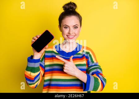 Photo d'un joli petit pain brun cheveux femme point téléphone écran copyspace wear chandail arc-en-ciel isolé sur fond jaune Banque D'Images