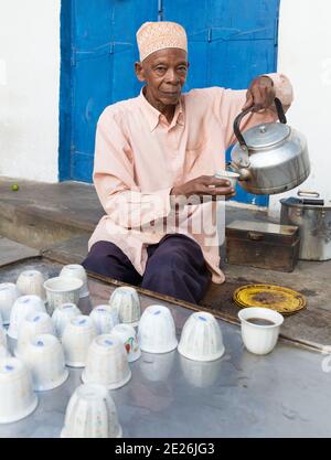 Homme âgé portant un chapeau Kofia traditionnel servant du café Banque D'Images