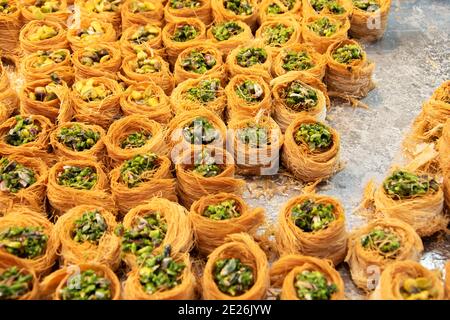 Baklava traditionnelle fraîche préparée avec des pistaches sur plateau métallique fond de confection du Moyen-Orient. Concept Sweet indulgence. Banque D'Images