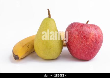 Gros plan d'une pomme rouge fraîche avec une banane et poire isolée sur fond blanc Banque D'Images