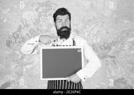 meilleur menu du chef. tableau noir avec espace pour le texte. boulanger professionnel en tablier. barista surpris avec barbe. publicité et nourriture. tableau vide pour le cuisinier. présentation du produit. oh mon dieu. Banque D'Images