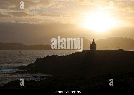 phare sur la côte au coucher du soleil Banque D'Images