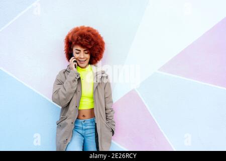 belle femme aux cheveux afro parlant sur son smartphone Banque D'Images