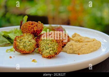 Télécharger un aperçu de trois boulettes de falafel, houmous et salade sur une assiette, nourriture du Moyen-Orient. Sélectif focus Banque D'Images