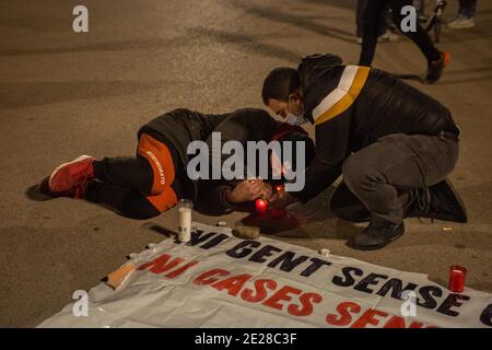 Barcelone, Catalogne, Espagne. 12 janvier 2021. L'homme couché est vu allumer la bougie en hommage aux sans-abri qui sont morts du froid.The Housing Union, de Barceloneta, un quartier de Barcelone, Ont appelé à un rassemblement pour deux résidents du quartier qui vivaient dans la rue et ont été les victimes fatales de la vague de froid qui hante l'Espagne. Les manifestants ont rendu hommage aux victimes et exigé un foyer digne pour tous les habitants de la rue. Credit: Thiago Prudencio/DAX/ZUMA Wire/Alay Live News Banque D'Images