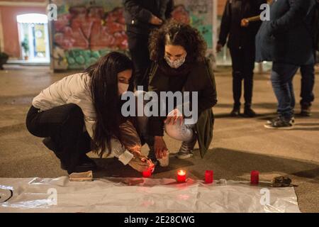 Barcelone, Catalogne, Espagne. 12 janvier 2021. Les femmes ont vu des bougies d'éclairage pour les sans-abri morts.le syndicat du logement, de Barceloneta, un quartier de Barcelone, ont appelé un rassemblement pour deux résidents du quartier qui ont vécu dans la rue et ont été les victimes fatales de la vague froide qui hante l'Espagne. Les manifestants ont rendu hommage aux victimes et exigé un foyer digne pour tous les habitants de la rue. Credit: Thiago Prudencio/DAX/ZUMA Wire/Alay Live News Banque D'Images