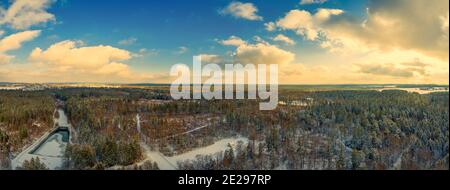 Vue d'hiver sur une maison idyllique au milieu d'une forêt couverte de neige blanche avec des sapins verts, vue panoramique aérienne de l'hiver Banque D'Images