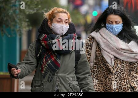 Les femmes portant des masques comme mesure préventive contre la propagation de la promenade Covid-19 le long de la rue à Londres.plus de 83,200 personnes ont perdu la vie de Covid-19 au Royaume-Uni. Le gouvernement est susceptible de faire respecter que les gens doivent porter une couverture faciale à l'extérieur, à moins qu'ils ne soient médicalement exemptés. Banque D'Images