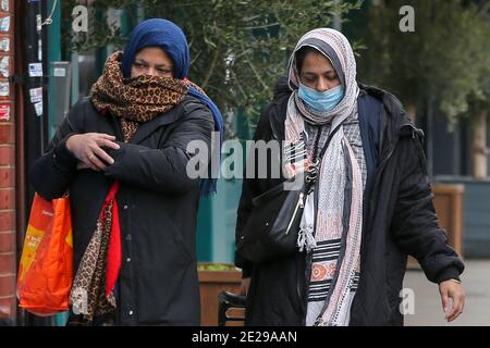 Londres, Royaume-Uni. 10 janvier 2021. Les femmes portant une couverture faciale comme mesure préventive contre la propagation de la promenade Covid-19 le long de la rue à Londres.plus de 83,200 personnes ont perdu la vie de Covid-19 au Royaume-Uni. Le gouvernement est susceptible de faire respecter que les gens doivent porter une couverture faciale à l'extérieur, à moins qu'ils ne soient médicalement exemptés. Credit: Dinendra Haria/SOPA Images/ZUMA Wire/Alay Live News Banque D'Images