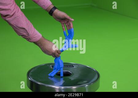 Retrait des gants en latex médical bleu protection contre la grippe, le virus et le coronavirus dans le studio a de chroma Banque D'Images