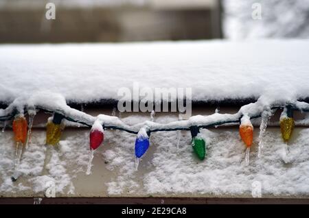 Sycamore, Illinois, États-Unis. Un groupe de lumières de Noël s'assoient dans la neige et la glace sur une maison du Midwest des États-Unis après une tempête d'hiver. Banque D'Images