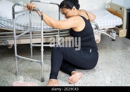 Dame asiatique femme d'âge moyen chute du patient dans la salle de séjour parce que les surfaces glissantes Banque D'Images