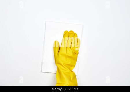 Une personne en gants de caoutchouc se lavant la surface en plastique blanc. Nettoyage d'une surface brillante à l'aide d'une lingette. Désinfection de la surface blanche Banque D'Images