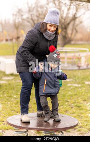 POZNAN, POLOGNE - 10 janvier 2021 : femme et enfant sur une plate-forme dans un terrain de jeu du parc Rataje. Banque D'Images