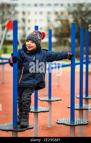 POZNAN, POLOGNE - 10 janvier 2021 : jeune enfant sur un équipement dans une aire de jeux du parc de Rataje. Banque D'Images