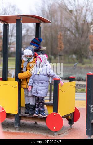 POZNAN, POLOGNE - 10 janvier 2021 : groupe d'enfants debout dans un équipement en forme de train dans une aire de jeux du parc Rataje. Banque D'Images