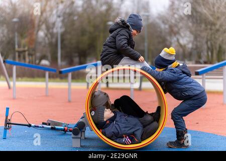 POZNAN, POLOGNE - 10 janvier 2021 : groupe d'enfants jouant dans un tunnel dans un terrain de jeu du parc Rataje. Banque D'Images