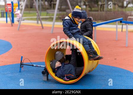 POZNAN, POLOGNE - 10 janvier 2021 : groupe d'enfants jouant dans un tunnel dans un terrain de jeu du parc Rataje. Banque D'Images