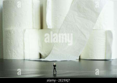 Figurine d'un homme contemplant son énorme stock de toilettes papier Banque D'Images