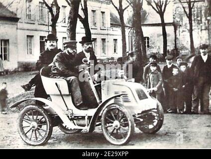 Photographie noir et blanc vintage prise à Rethel, Ardennes, France de la voiture Bauchet avec chauffeur et deux passagers. Probablement Henry Bauchet lui-même. Banque D'Images