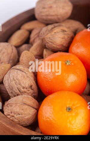 Noix, amandes et oranges dans un bol en bois. Banque D'Images