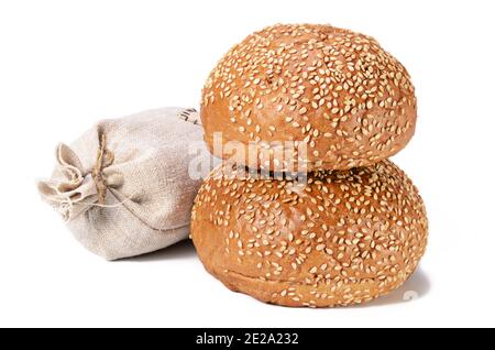 petit pain frais, parsemé de graines de sésame sur un fond blanc avec une ombre douce Banque D'Images