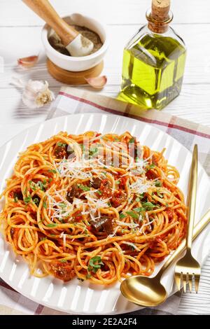 plat traditionnel de pâtes siciliennes d'aubergines sautées avec sauce tomate et nappé de parmesan râpé servi sur une assiette blanche, cuisin italien Banque D'Images