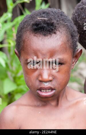 Wamena, Indonésie - 9 janvier 2010 : Portret de l'enfant de la tribu Dani. Garçon regardant la caméra, Papouasie-Nouvelle-Guinée. Banque D'Images