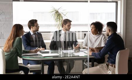 Les employés multiraciaux discutent d'idées commerciales lors d'un briefing Banque D'Images