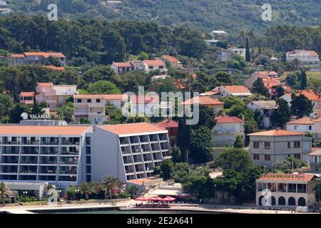 Croatie, région de Kvarner, Rab Island Hôtel moderne sur le front de mer avec des collines derrière elle. Banque D'Images