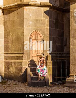 Une fille est assise sur un escalier près de l'église noire À Brasov Banque D'Images