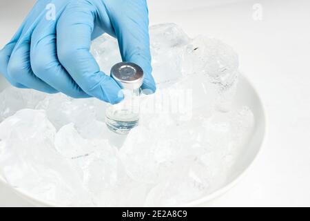 Un médecin prenant un flacon de vaccin du réfrigérateur froid et prépare l'injection. Flacons sur la glace. Conservation à long terme du vaccin Covid-19. Coronavirus Banque D'Images