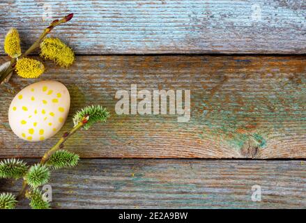 Composition de fleurs de pâques rameaux de saule et d'oeufs de Pâques avec un motif de points jaunes sur un fond rétro en bois avec copie espace top view close- Banque D'Images