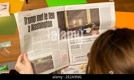 Paris, France - 7 janvier 2020: Une femme lisant sur son canapé journal français libération interiour page show storming of the U.S. Capitol by Supporters of U.S. President Donald Trump on January 07, 2021 Banque D'Images