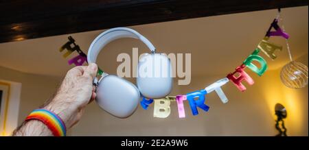 Paris, France - 7 janvier 2020: Image large - affiche d'anniversaire happy accroché dans la chambre avec des écouteurs AirPods Max Apple sur la main d'homme happy - un cadeau idéal pour des vacances d'anniversaire Banque D'Images