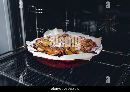 Gâteau rustique aux prunes fraîchement cuit à la maison dans le four de la cuisine. Cuisson maison. Banque D'Images