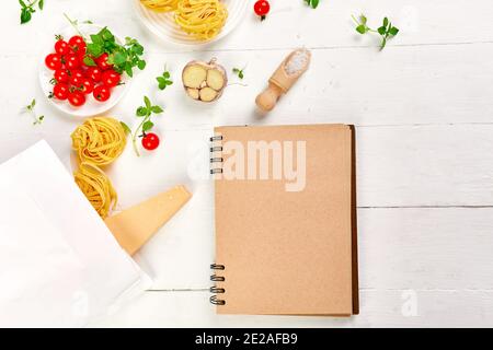 Alimentation saine dans un sac de papier d'épicerie avec carnet vierge, Ingrédients pour la cuisson des pâtes italiennes sur fond blanc, concept de supermarché de shopping, C Banque D'Images